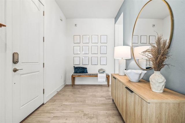 interior space with baseboards and light wood finished floors