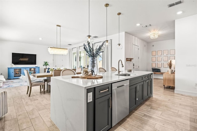 kitchen with open floor plan, visible vents, a sink, and stainless steel dishwasher