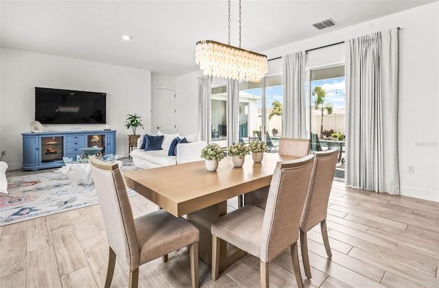 dining space with visible vents, recessed lighting, light wood-style flooring, and an inviting chandelier