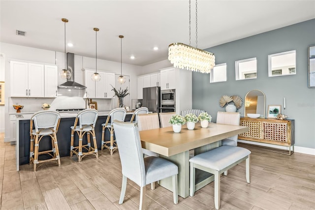 dining room featuring light wood-style floors, baseboards, visible vents, and recessed lighting