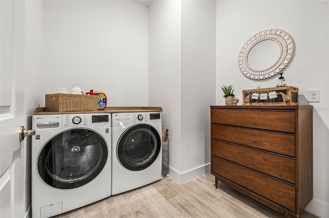 clothes washing area featuring baseboards, laundry area, independent washer and dryer, and light wood-style floors