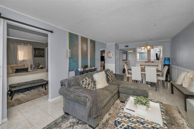 tiled living area with visible vents, a textured ceiling, radiator heating unit, and an inviting chandelier