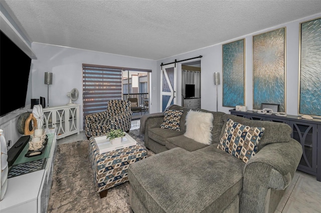 tiled living room featuring a textured ceiling and a barn door