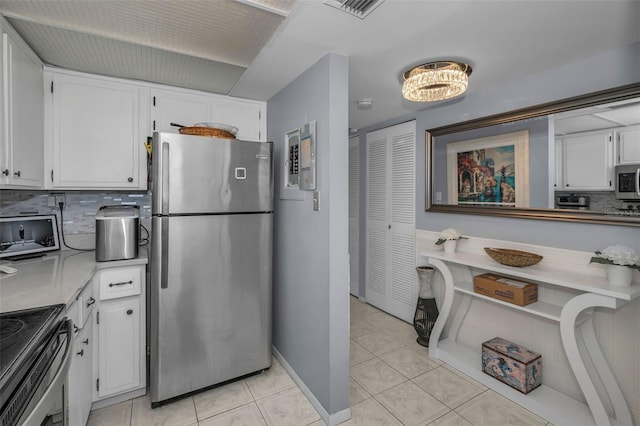 kitchen featuring appliances with stainless steel finishes, tasteful backsplash, white cabinets, and light tile patterned floors