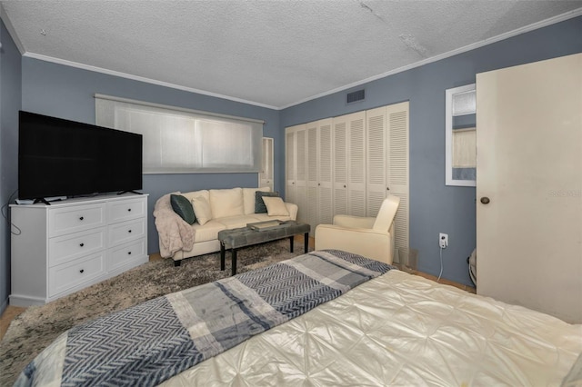 bedroom with a textured ceiling, ornamental molding, a closet, and visible vents