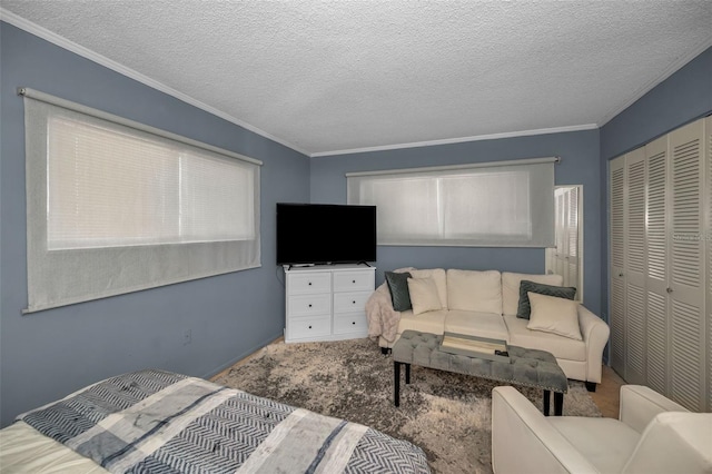 bedroom featuring carpet, a closet, crown molding, and a textured ceiling