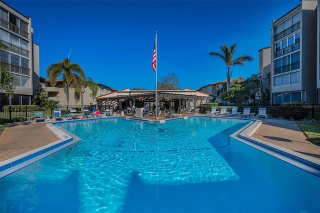 community pool with fence and a patio