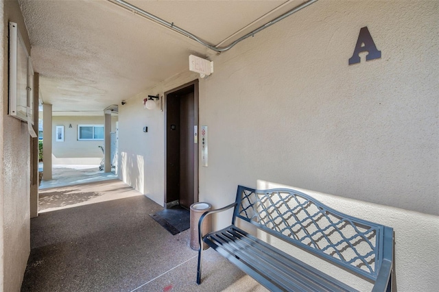 property entrance with elevator and stucco siding