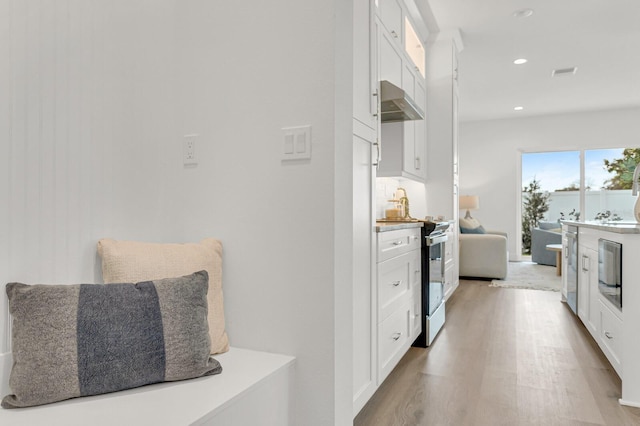 kitchen with recessed lighting, visible vents, electric range oven, white cabinetry, and wood finished floors