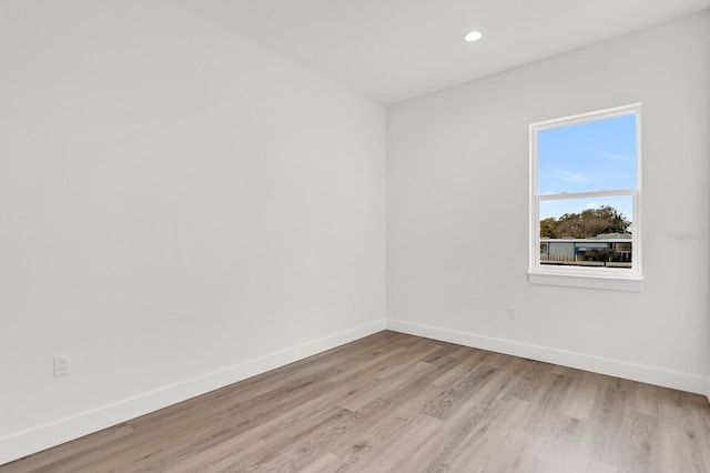 empty room with light wood-style floors, recessed lighting, and baseboards