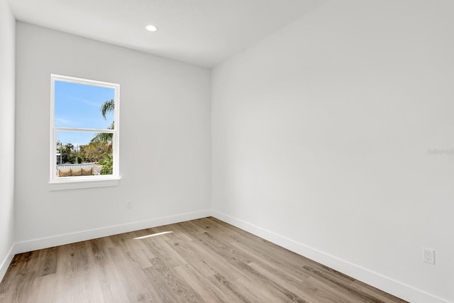 empty room featuring light wood-style floors, baseboards, and recessed lighting