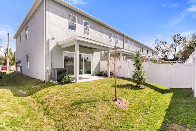 back of house featuring a patio, stucco siding, a lawn, central AC unit, and fence