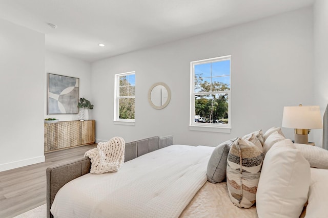 bedroom featuring baseboards, wood finished floors, and recessed lighting