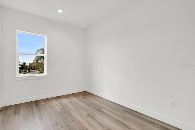 spare room featuring light wood-style floors, recessed lighting, and baseboards