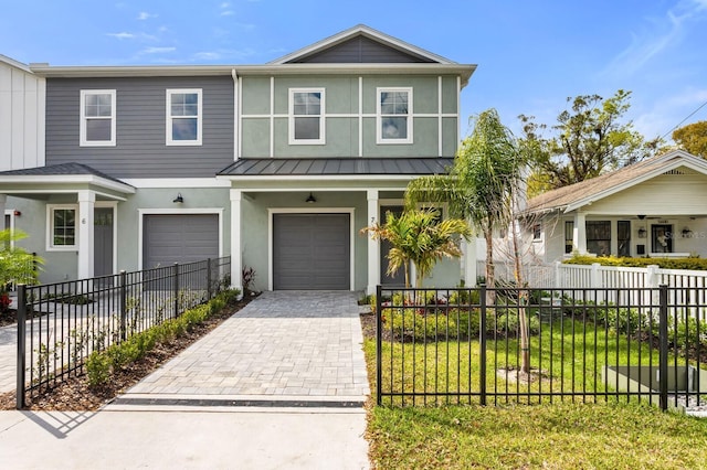 view of front of house with a fenced front yard, metal roof, a standing seam roof, decorative driveway, and stucco siding