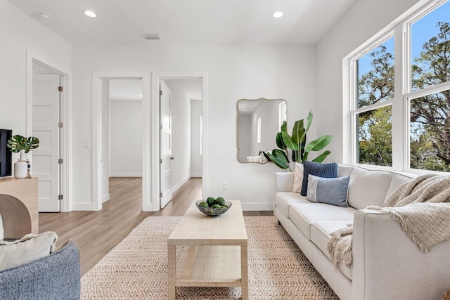 living room with light wood-style floors, baseboards, visible vents, and recessed lighting