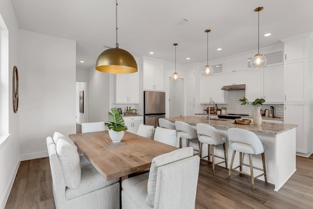 dining area with visible vents, baseboards, wood finished floors, and recessed lighting