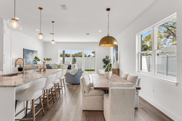 dining space with recessed lighting, visible vents, baseboards, and wood finished floors