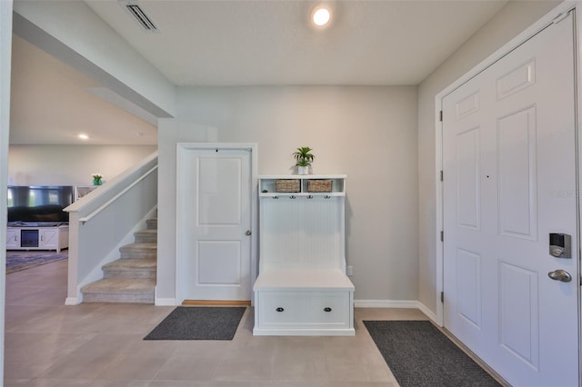 entrance foyer with stairway, tile patterned floors, visible vents, and baseboards