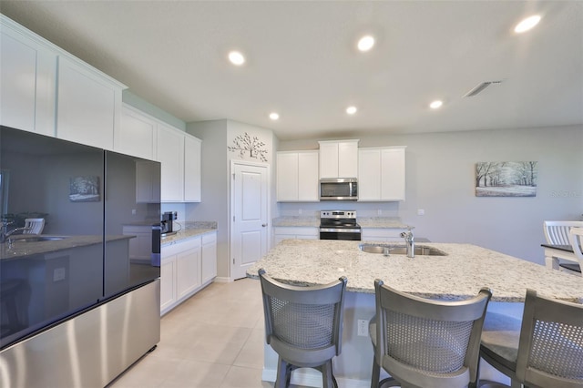 kitchen featuring visible vents, white cabinets, stainless steel appliances, a sink, and recessed lighting