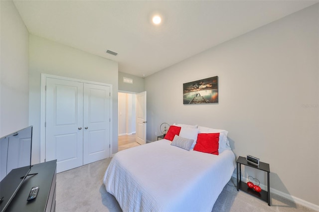 bedroom with baseboards, visible vents, a closet, and light colored carpet