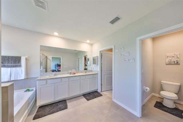 bathroom with visible vents, toilet, a bath, and double vanity