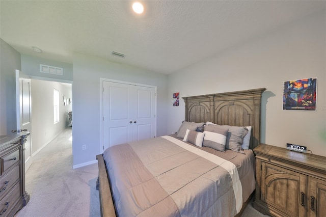 bedroom featuring light colored carpet, a closet, visible vents, and baseboards