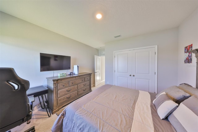 bedroom with visible vents, a closet, and light colored carpet