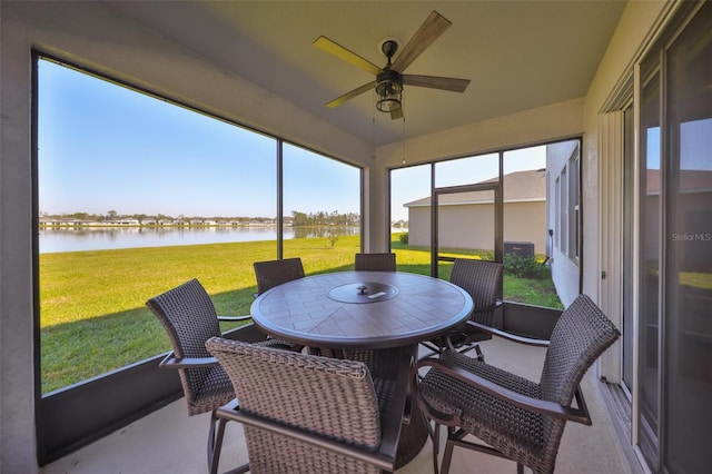 sunroom / solarium featuring a water view and ceiling fan