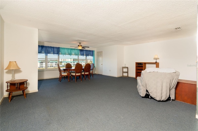 interior space with carpet floors, a textured ceiling, visible vents, and a ceiling fan