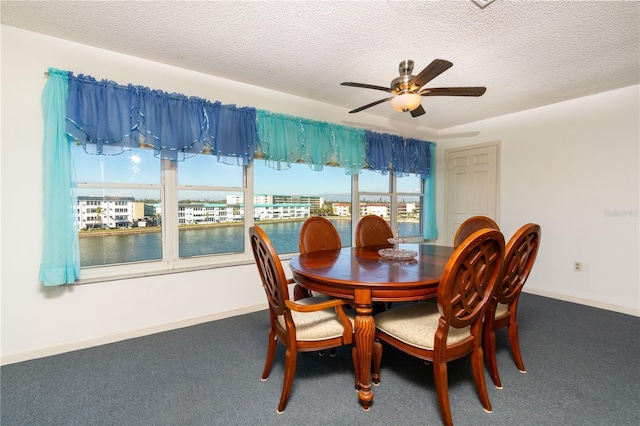 carpeted dining area featuring a textured ceiling, ceiling fan, and baseboards