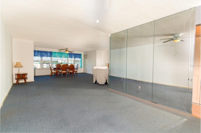 carpeted empty room featuring a textured ceiling and a ceiling fan