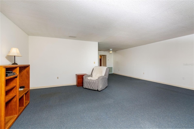 unfurnished room featuring visible vents, baseboards, ceiling fan, carpet, and a textured ceiling