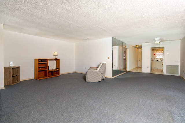 carpeted spare room featuring a ceiling fan, baseboards, visible vents, and a textured ceiling