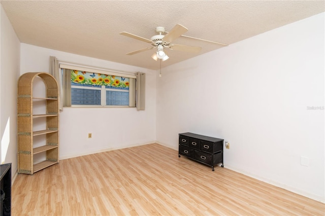 spare room with ceiling fan, a textured ceiling, and wood finished floors