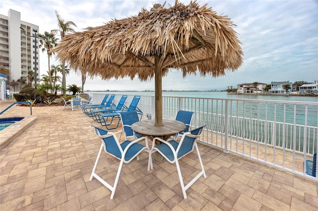 view of patio with a water view and outdoor dining area