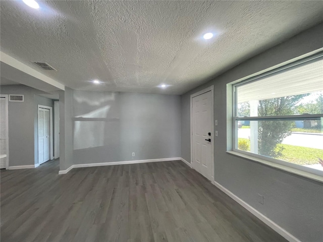 interior space with baseboards, visible vents, and dark wood-type flooring