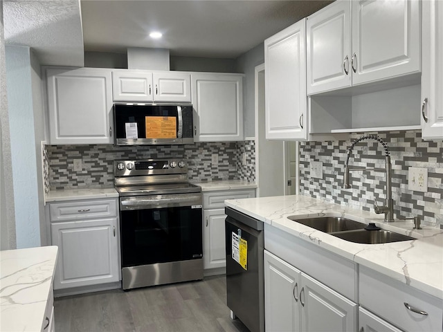 kitchen featuring open shelves, stainless steel appliances, white cabinets, a sink, and wood finished floors