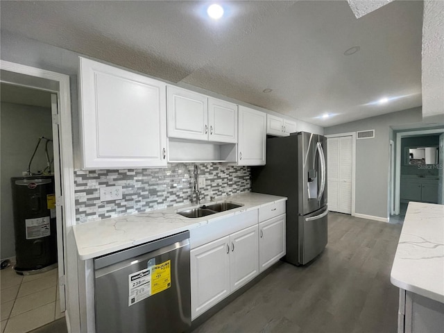 kitchen featuring white cabinetry, visible vents, appliances with stainless steel finishes, and electric water heater