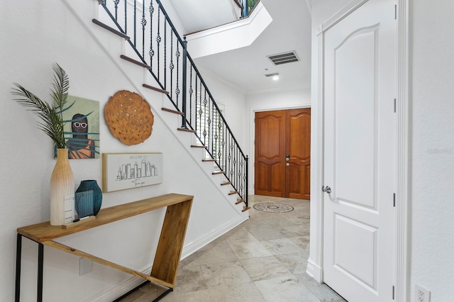 entrance foyer featuring a skylight, visible vents, baseboards, and stairs