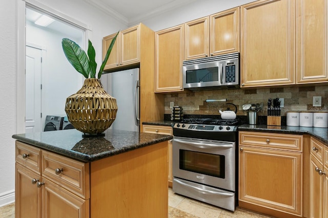 kitchen with stainless steel appliances, ornamental molding, backsplash, a center island, and washing machine and clothes dryer