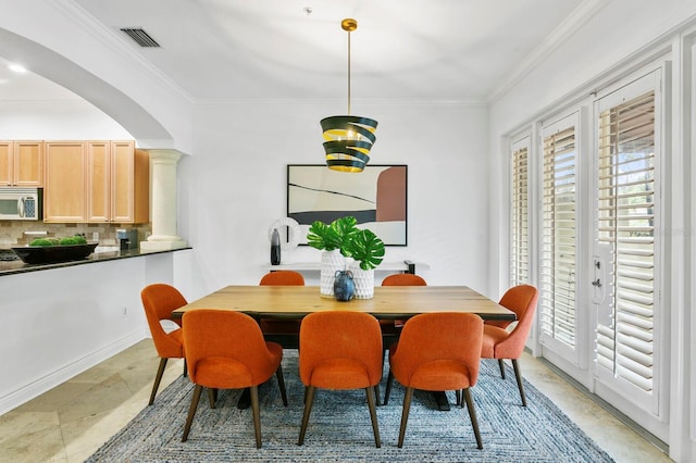 dining space featuring arched walkways, ornamental molding, visible vents, and ornate columns