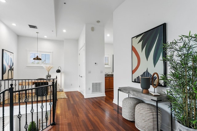 hall with dark wood-style flooring, recessed lighting, visible vents, and baseboards