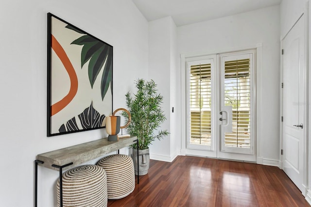 doorway to outside featuring baseboards and wood finished floors