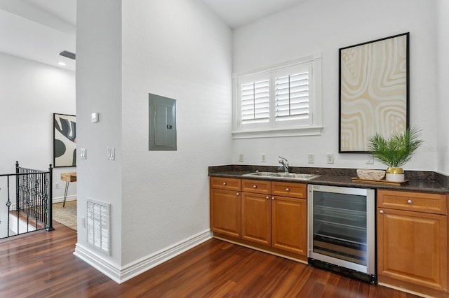 bar featuring beverage cooler, electric panel, visible vents, dark wood-style floors, and a sink