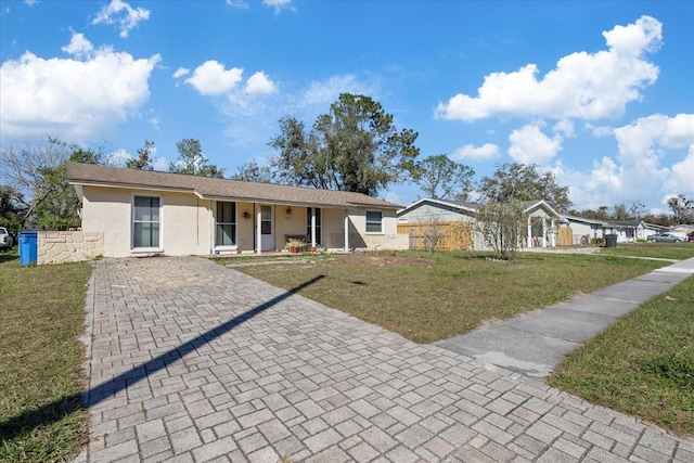 ranch-style home featuring fence, a front lawn, and stucco siding