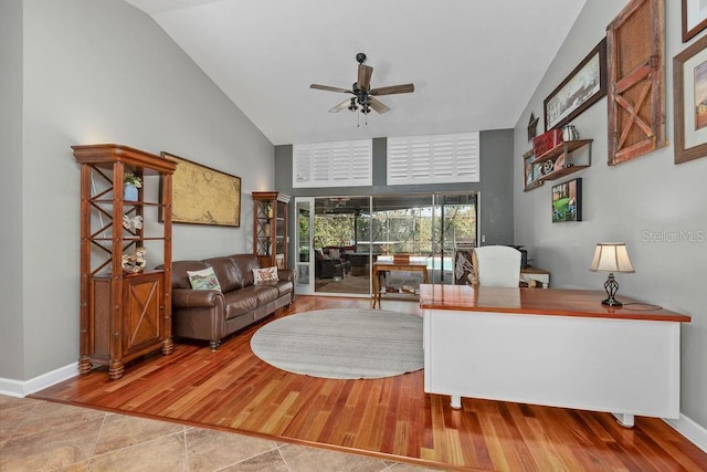 living room featuring high vaulted ceiling, a ceiling fan, baseboards, and wood finished floors