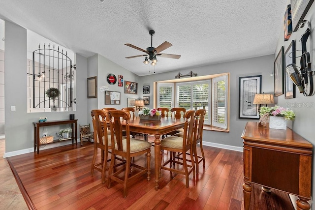 dining room with ceiling fan, baseboards, vaulted ceiling, and wood finished floors