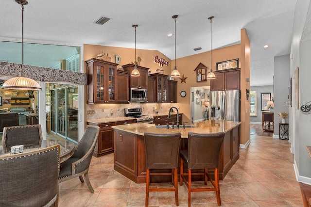 kitchen featuring a sink, visible vents, appliances with stainless steel finishes, tasteful backsplash, and glass insert cabinets