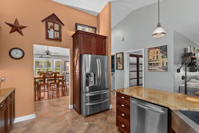 kitchen with hanging light fixtures, high vaulted ceiling, appliances with stainless steel finishes, and light stone counters